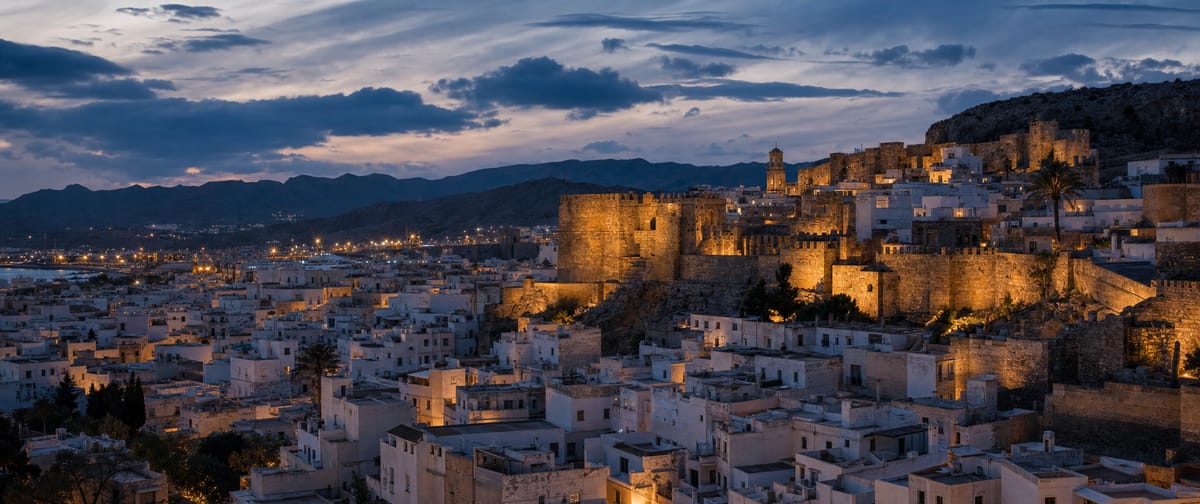 The Almedina and the walls lit up at nightfall, like a natural film set